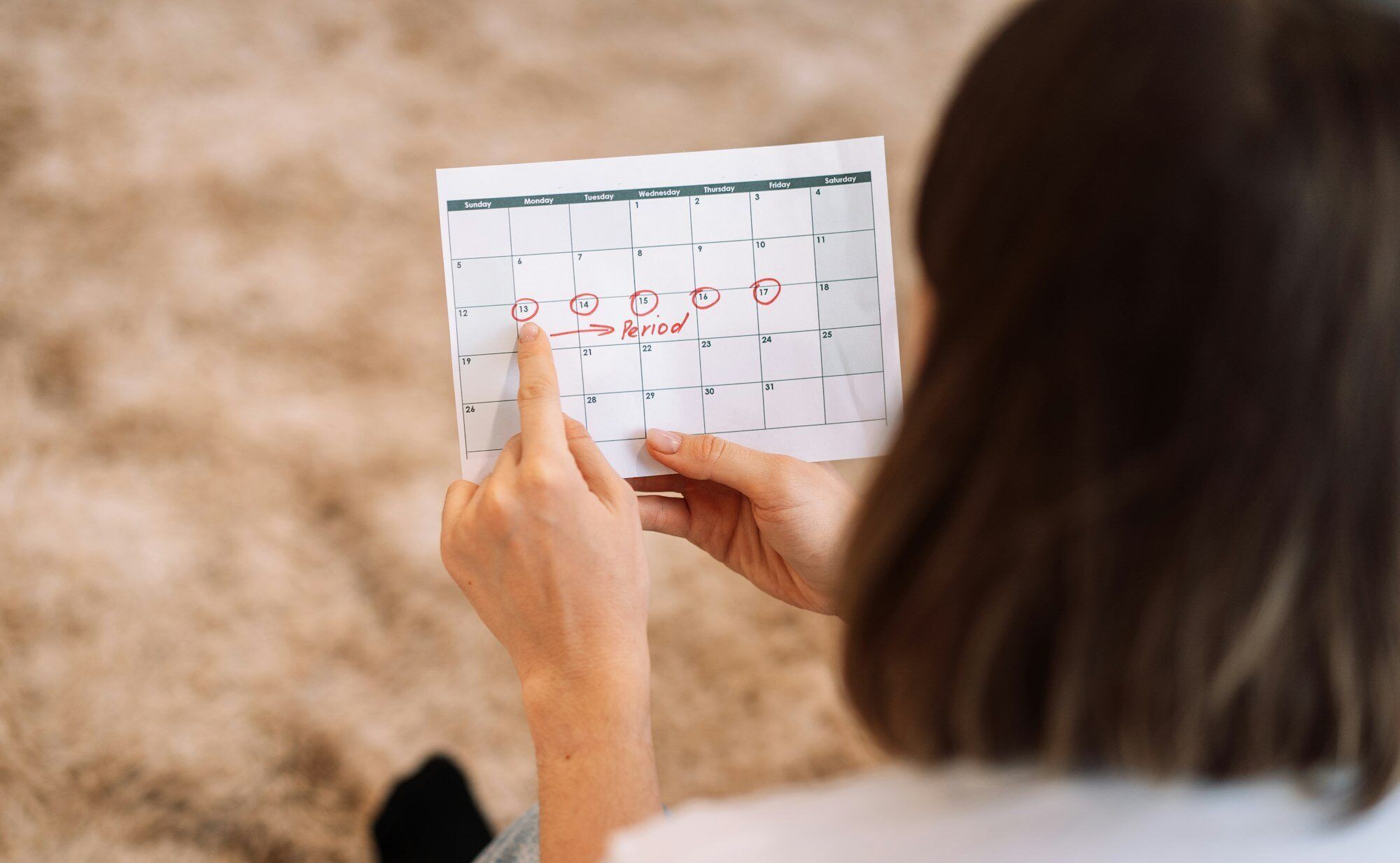 Lady looks at the days in the calendar menstrual cycle